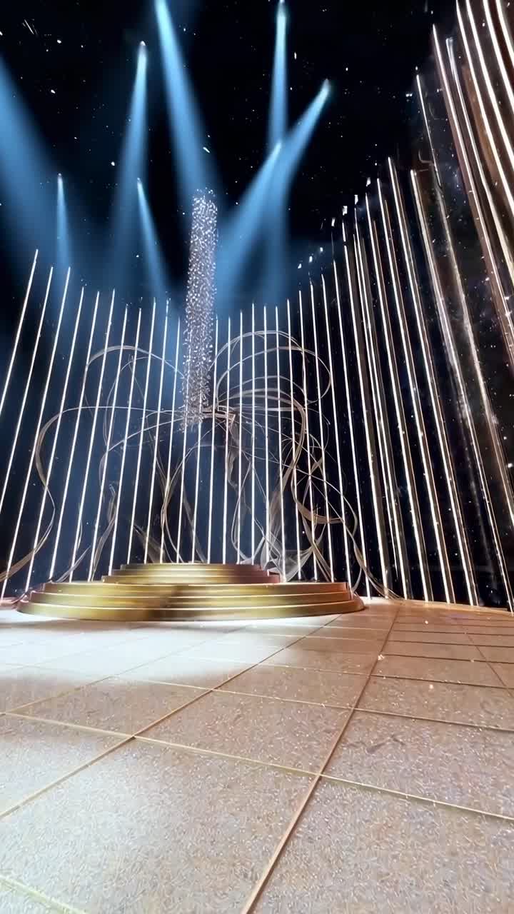 Vídeo dinâmico em ângulo baixo de um palco glamoroso com luzes douradas e padrões em espiral.