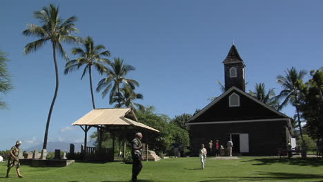 la gente llega a una iglesia tropical cuando suena la campana