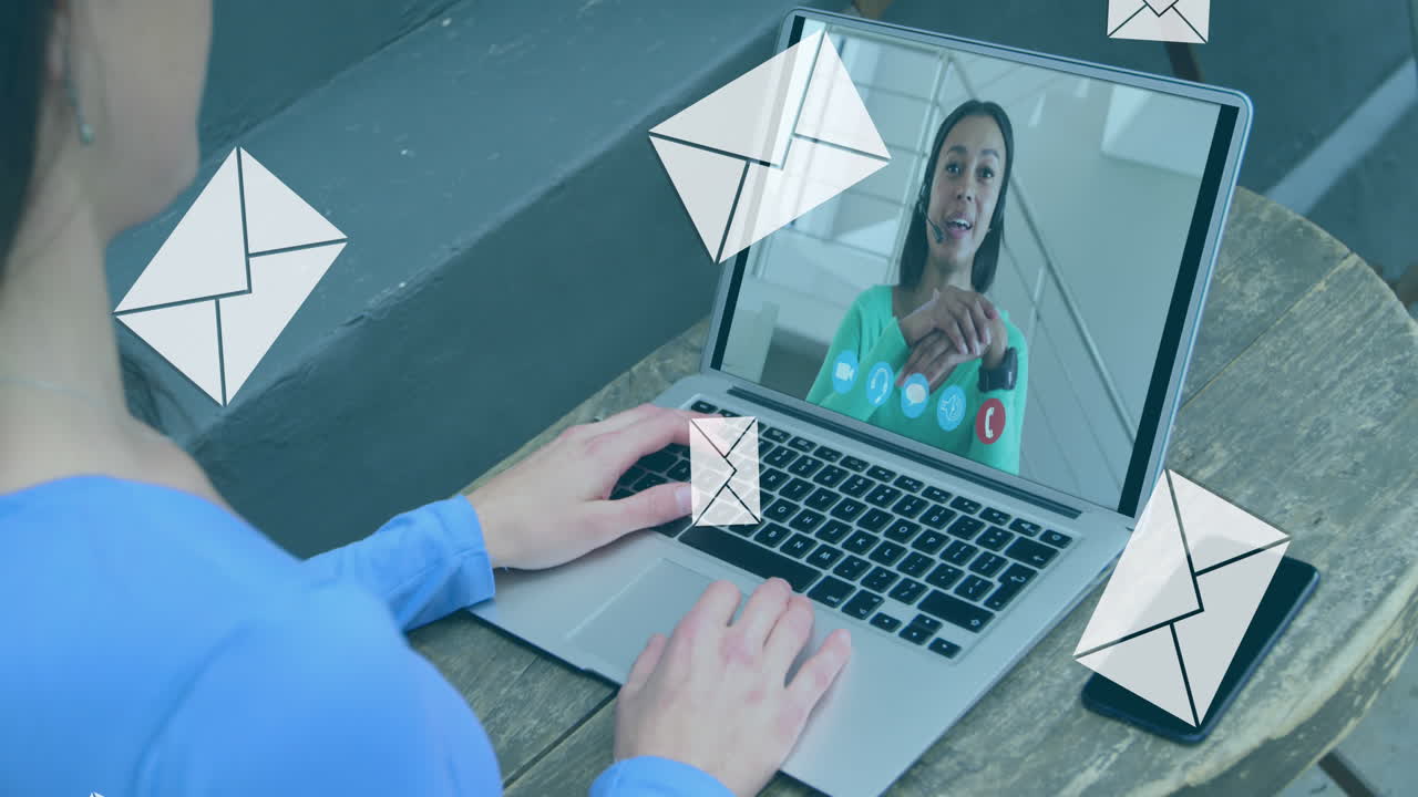 Animazione di icone di buste email digitali su una donna che usa un laptop in videochiamata