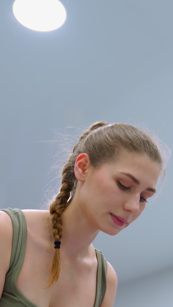 la mujer realiza un ejercicio de fitness, enfocada y comprometida, con luces por encima que iluminan su movimiento, la atmósfera tranquila y la iluminación brillante mejoran su concentración durante el entrenamiento