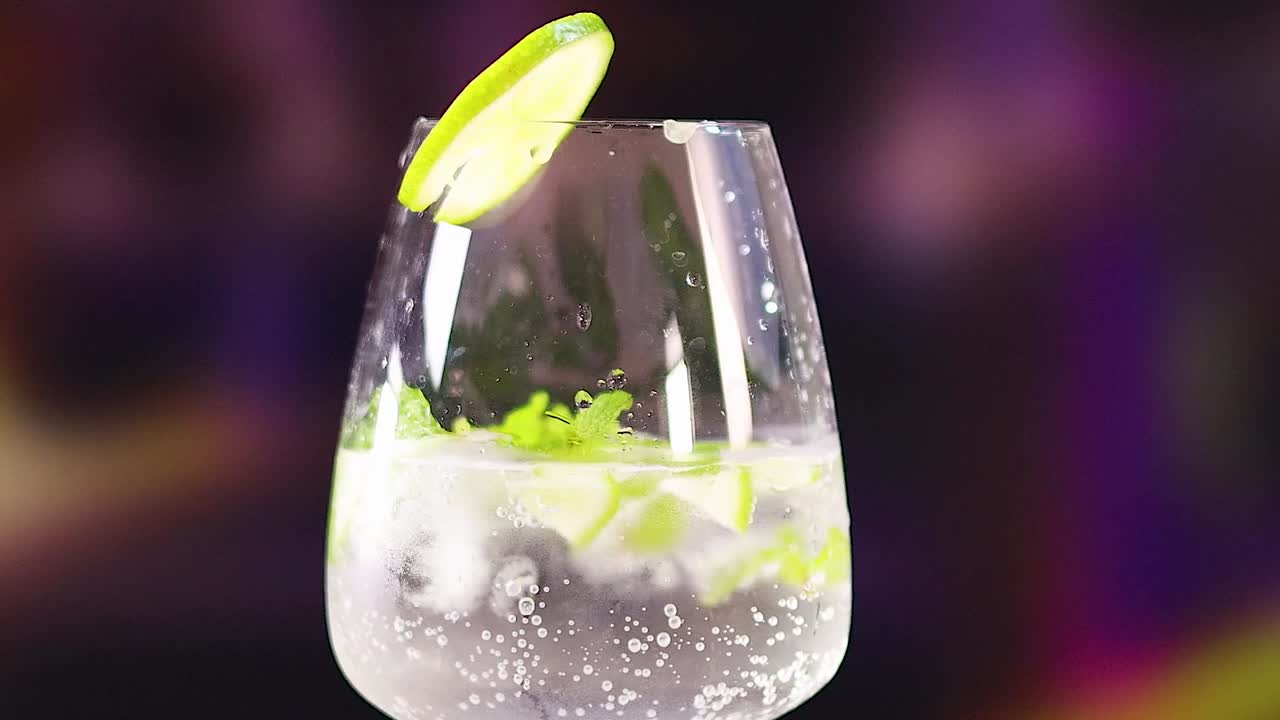 Un rinfrescante cocktail mojito frizzante con lime fresco e foglie di menta in un bicchiere