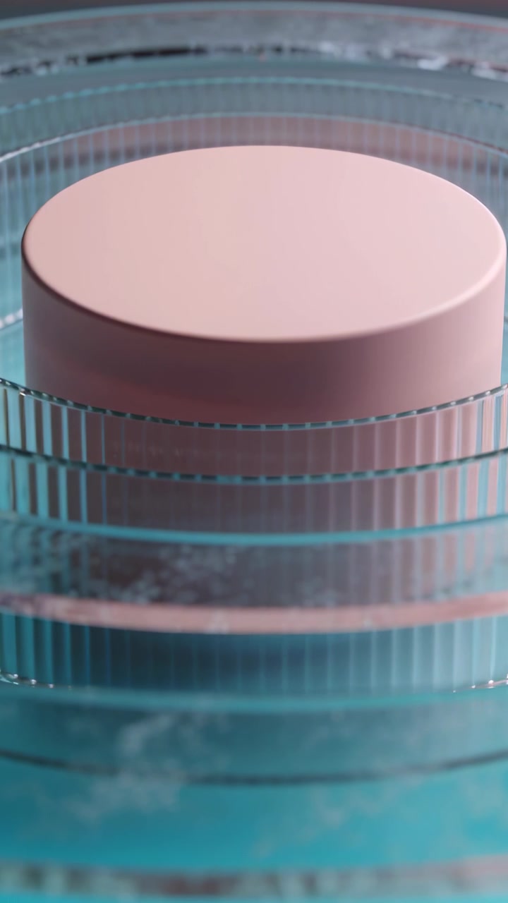Vertical video: Moving camera showcasing matte pink jar on ribbed rings in set, mist and teal glow