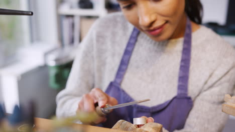 Close-Up-Of-Female-Jeweller-Working-On-Ring-With-File-In-Studio