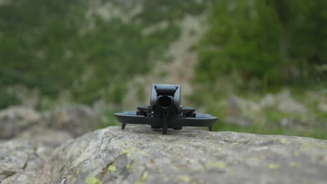 drone dji avata lifting from rocky flat ground, ready to fly, mountain scenery