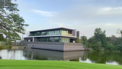 contemporary architecture beside tranquil water and greenery