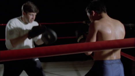 dos boxeadores peleando en un ring de boxeo 2