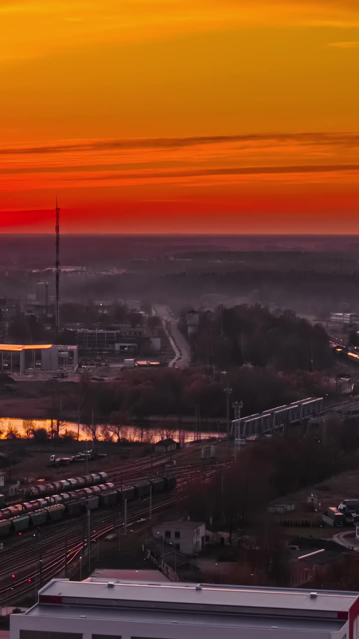 Vibrant sunset over cityscape with train tracks, creating a serene mood
