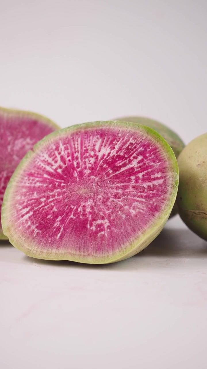 Ravanello anguria rosa vivace affettato su bianco