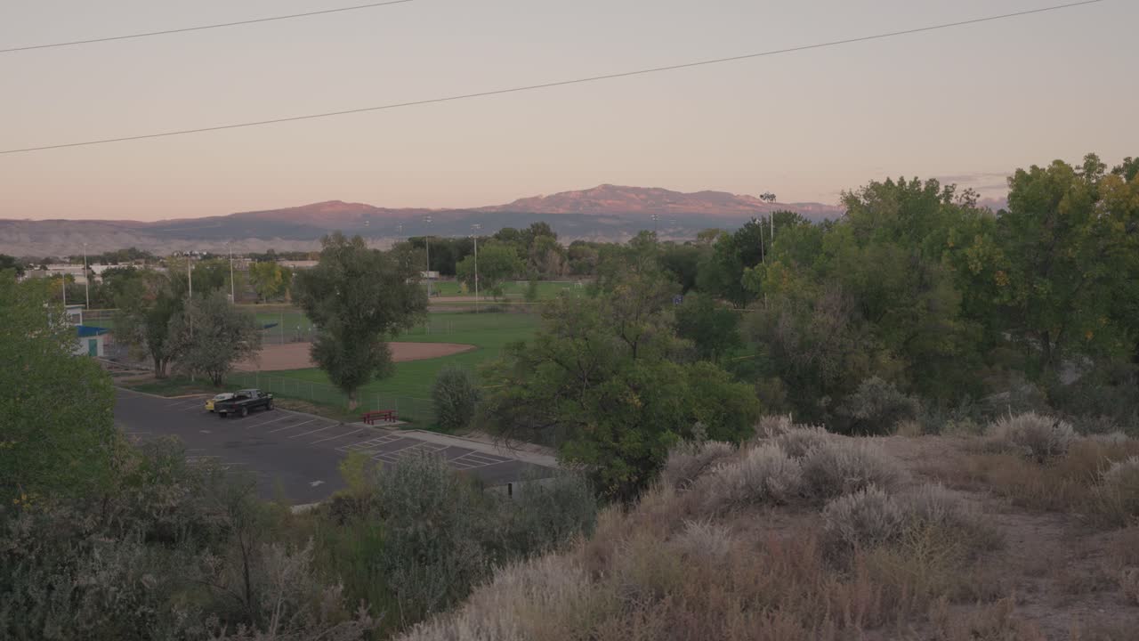 Scenic Landscape with Mountains, Field, and Sunset