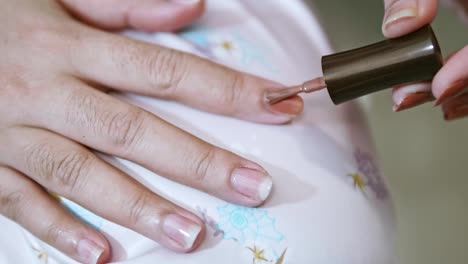 closeup of a woman paints her nails by self made manicure at home slow motion scene