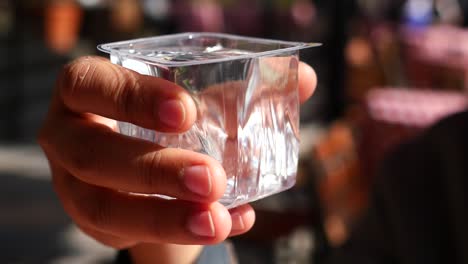 hand holding a plastic cup of water