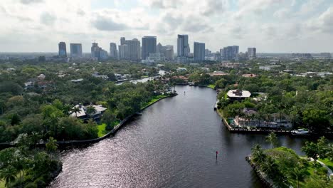 aerial pullout fort lauderdale skyline in background with luxury homes in foreground along waterway