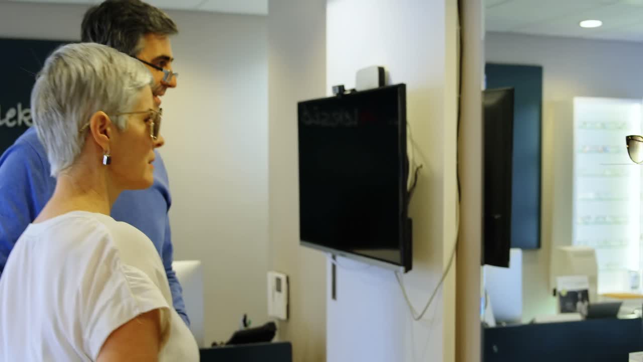 Senior woman selecting frame 4k