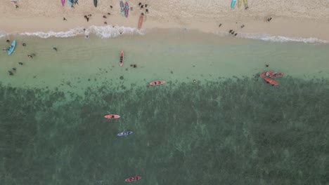 Diversión-En-La-Playa-Con-Kayaks-Y-Tomar-El-Sol-En-Indonesia,-Vista-Aérea-De-Arriba-Hacia-Abajo