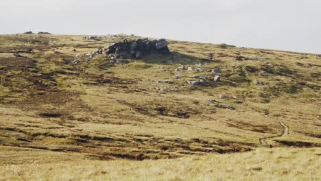 timelapse of sheep roaming near a jagged rock formation on rugged moorland, peak district, england