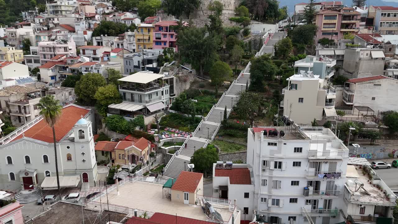Patras by,luftfoto, halvcirkelformet panorering til venstre rundt om de berømte Saint Nicholas Stairways. Folk går op ad trappen, omgivet af grønne områder og farverige bygninger.
