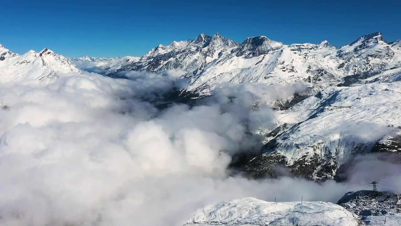 Paesaggio innevato di nuvole e nebbia sopra una catena montuosa, ripresa aerea