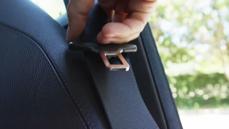 hand holding seat belt of car