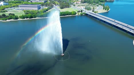 drone aerial landscape of water jets spraying in lake basin captain james cook memorial fountain and car vehicles on bridge traffic overpass canberra city act australia travel tourism architecture