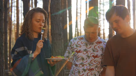 amigos disfrutando de un almuerzo de picnic en el bosque