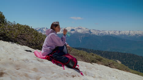 woman hiking in mountains, drinking water