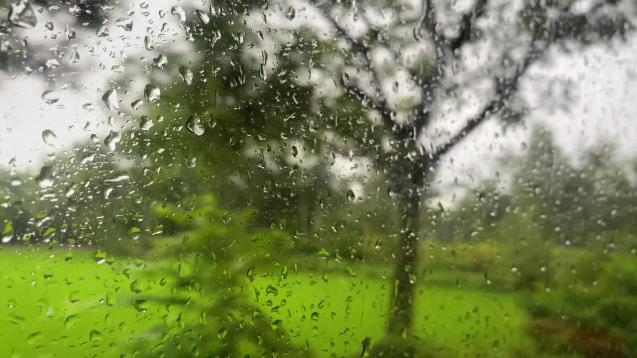 Rain droplets on a bus window driving on bumpy road