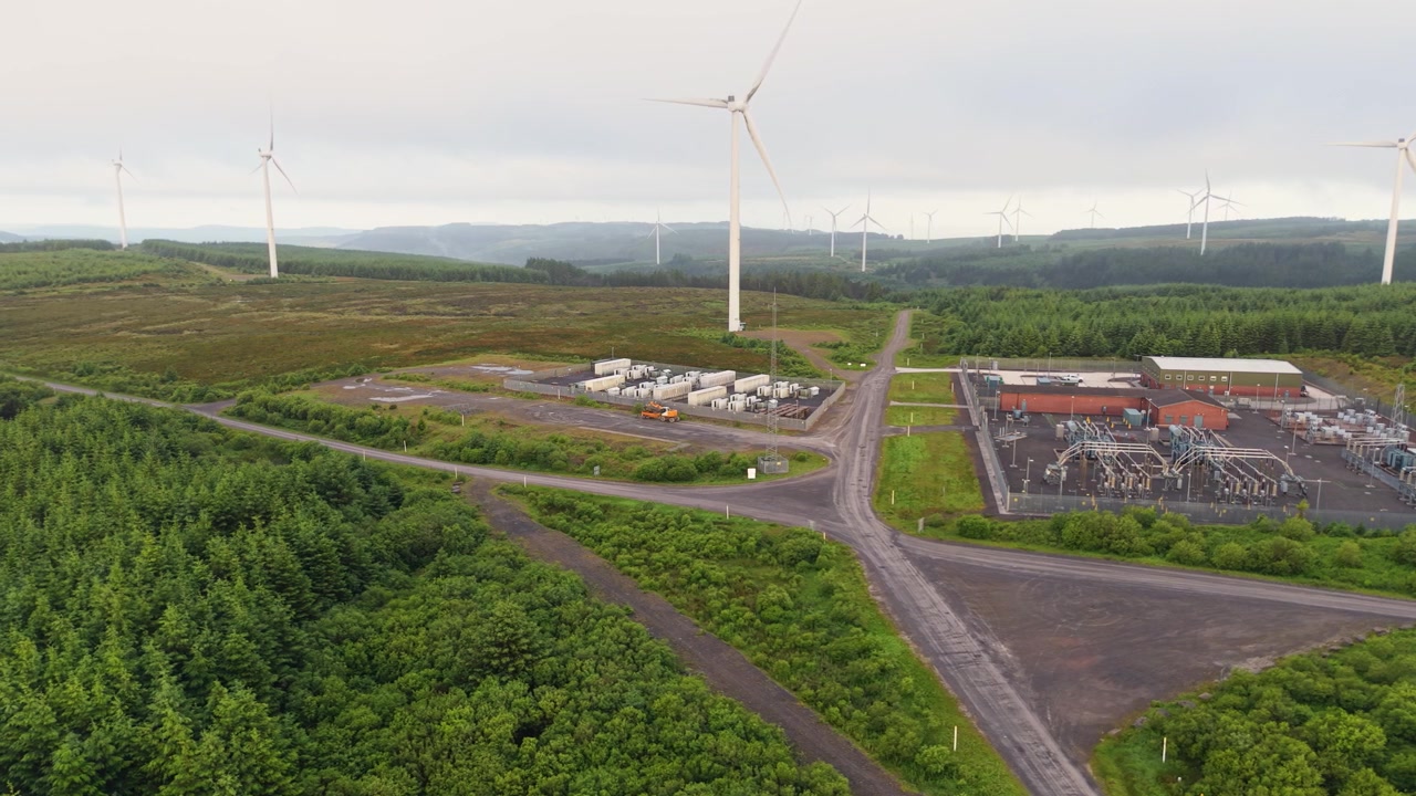 Wide Landscape with BESS Battery Energy Storage System Facility on Wind Farm with Substation in South Wales, UK. Powering Net Zero Energy Transition.