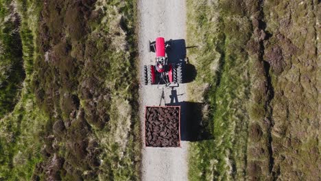 disparo de drone a vista de pájaro de un tractor lleno de turba