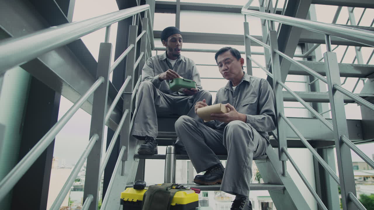 Builders Eating Lunch on Stairs of Building under Construction