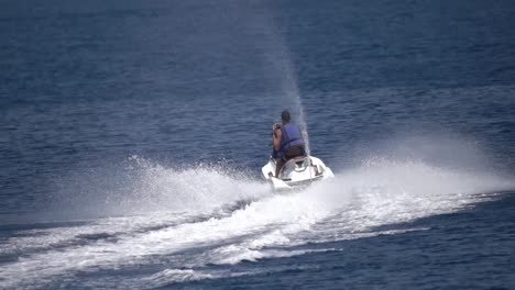 young man turning on jetski in mediterranean sea in slow motion action shot