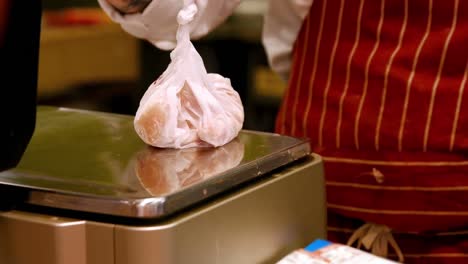 personal masculino pesando el alimento en la escala de peso