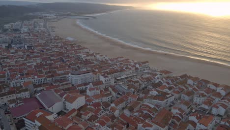 Flächendrohnenaufnahmen-Der-Stadt-Nazare-An-Der-Küste-Portugals,-Gefilmt-Während-Der-Goldenen-Stunde-Des-Sonnenuntergangs-4k