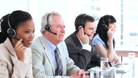 Serious-call-centre-agents-talking-with-headsets