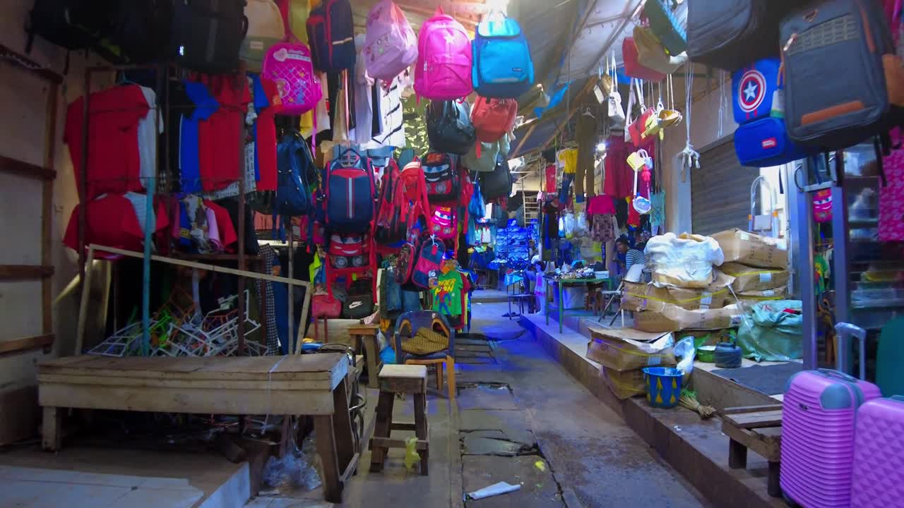 POV shot of walking down the local clothes shop during nighttime in Serekunda Market of Gambia.