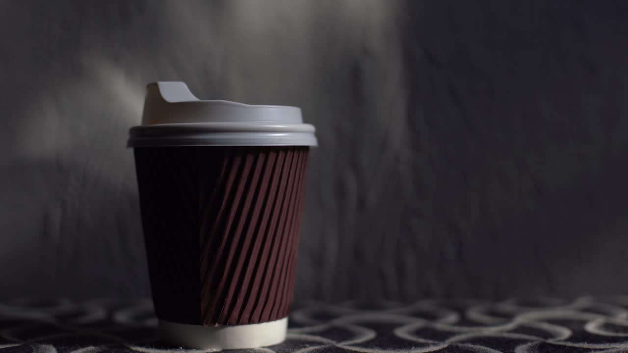 Bicchiere di caffè da asporto su uno sfondo di legno marrone