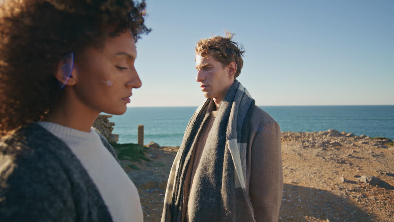 Sad couple posing ocean cliff closeup. Curly woman blonde man feeling upset