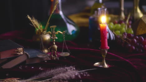 symbolic balance: lit red candle and scale of justice with sword and feather