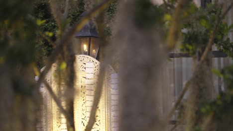 kerosene lamp burning at dusk slider shot looking through foliage