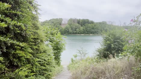 Embalse-De-Aggertalsperre-En-Alemania-Entre-Bosques-Con-Pequeñas-Escaleras-De-Piedra-Hasta-El-Banco-Con-Ráfagas-A-Su-Alrededor