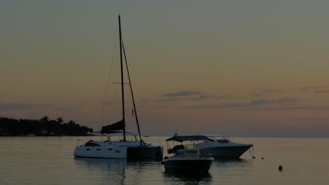 a static shot of three boats, two with single hull and a catamaran