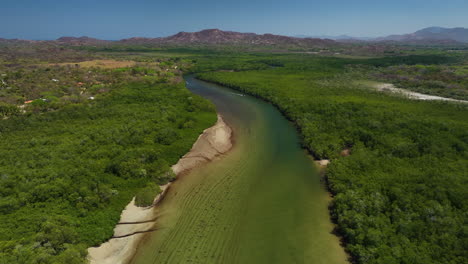 vista aérea siguiendo el río estero de playa grande, un día soleado en costa rica