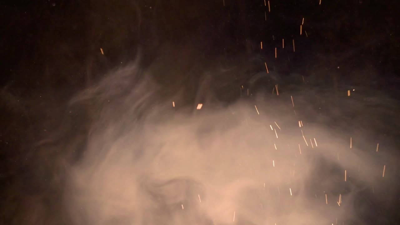 Fumo atmosferico e scintille luminose su uno sfondo scuro