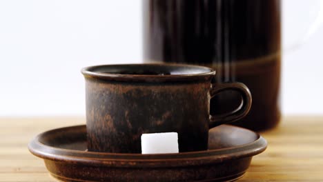 Cafetiere-and-a-cup-of-black-coffee-on-table