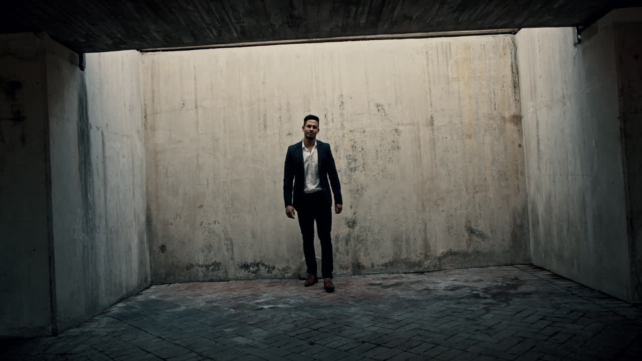 Man in a suit stands in a concrete tunnel
