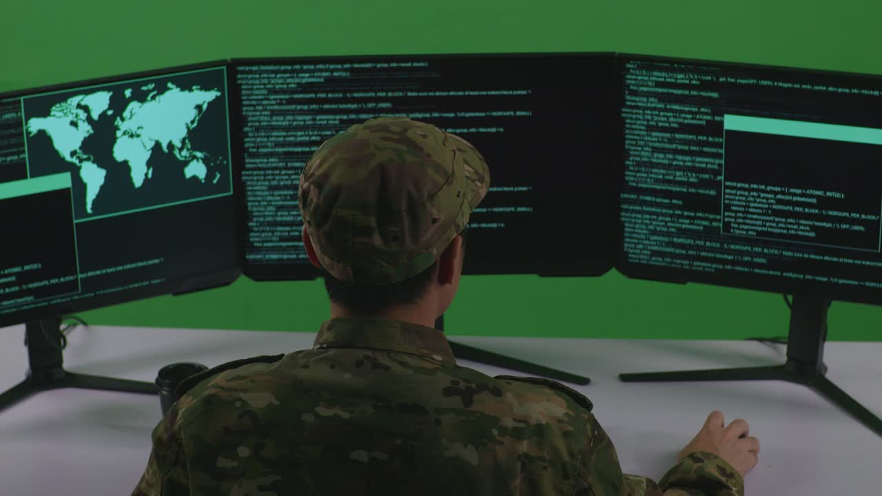Soldier working on multiple computer monitors
