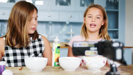 two girls recording vlog at home showing how to make slime