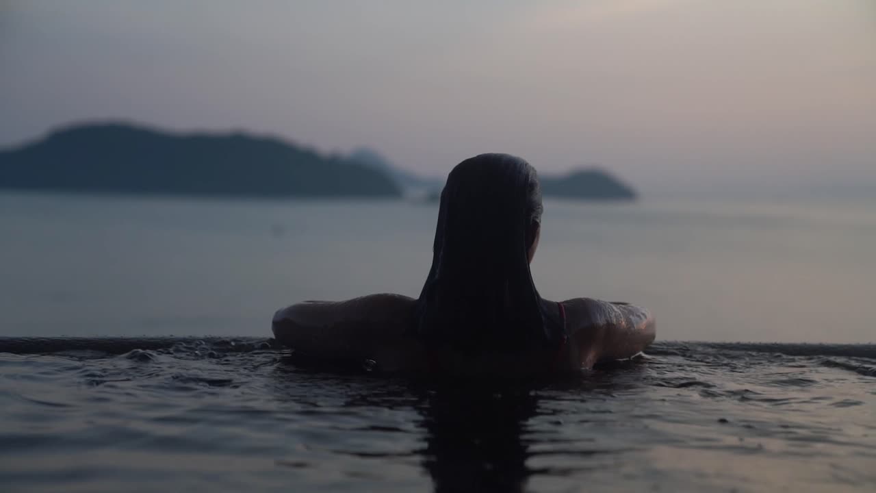 60fps model swimming in an infinity pool in thailand
