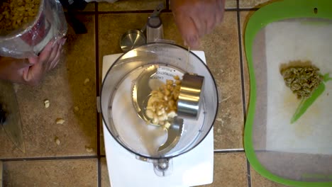 vertiendo nueces de cajú en un procesador de alimentos, vista desde arriba