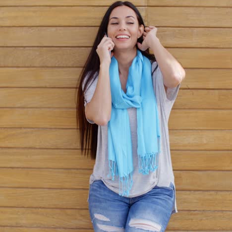 mujer al teléfono y apoyada contra la pared