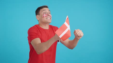 Nervous man cheering for Denmark during a match looking away